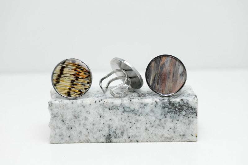 Three Silver Statement Rings on black and white marble on a white background.