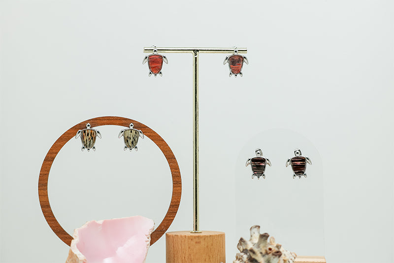 Three pairs of Mini Silver Turtles on stands on a white background with two shells at the bottom of the image.