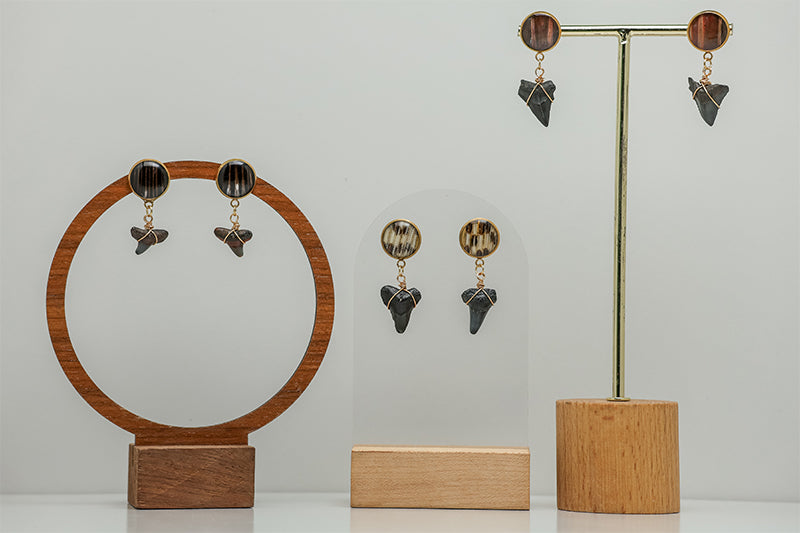 Three Shark Tooth Gold Posts on stands on a white background. 