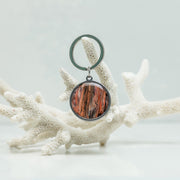 A Silver Keychain ring on white coral on a white background. 