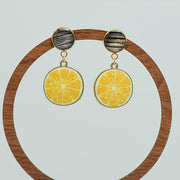 Limoncello Earrings on a circular wooden stand on a white background.  
