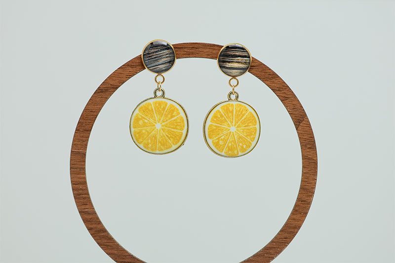 Limoncello Earrings on a circular wooden stand on a white background.  