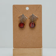 Golden Palm Earrings on a cardboard stand on a white background.