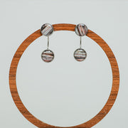 Ear Jacket Post Earrings on a circular wooden stand on a white background.  