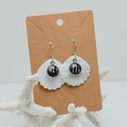 A pair of Iridescent Mother of Pearl Dangles on a cardboard stand on white coral on a white background. 