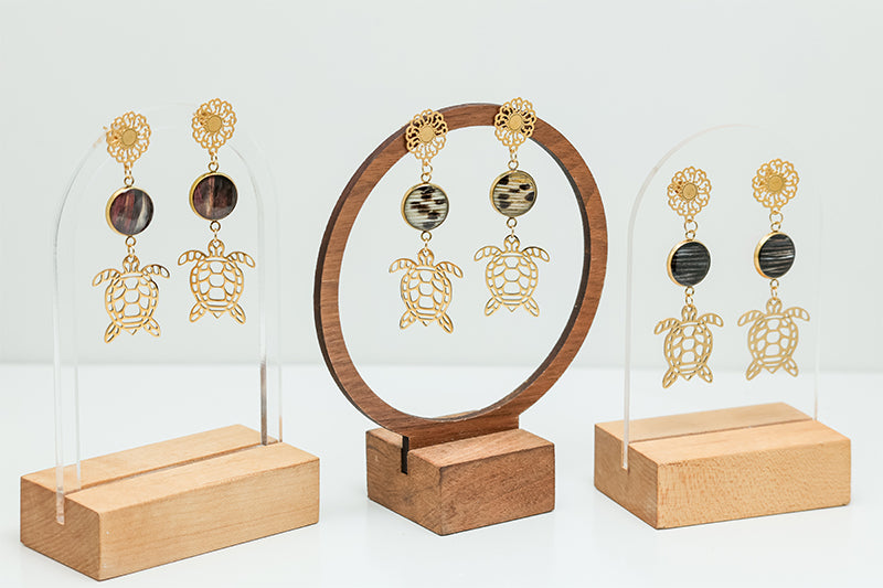 Three pairs of Sea Turtle Mandala Drops on stands on a white background. 