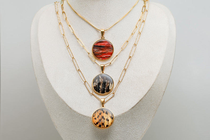 Three X-Large Gold Necklaces on a cream necklace display bust. 