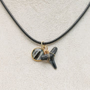 A Shark Tooth Necklace on a cream necklace display bust. 