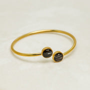 A Gold Double Pendant Cuff on a white background with a gold frame. 