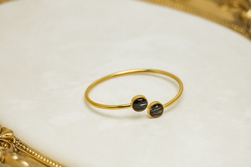 A Gold Double Pendant Cuff on a white background with a gold frame. 
