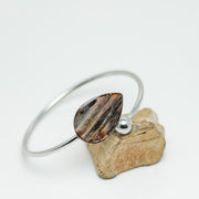Silver Teardrop Cuff on a rock on a white background. 