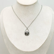A Teardrop Necklace on a cream necklace display bust. 