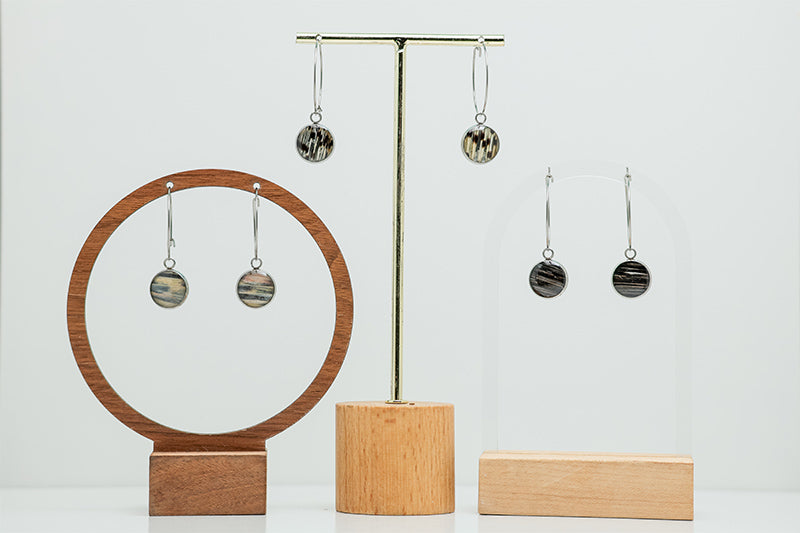 Three pairs of Silver Hoops on stands on a white background.  