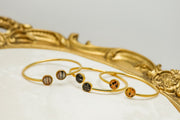 Three Gold Double Pendant Cuffs on a white background with a gold frame. 
