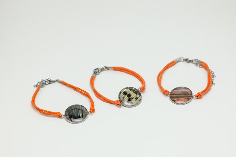 Three Orange Cord Bracelet on a white background. 