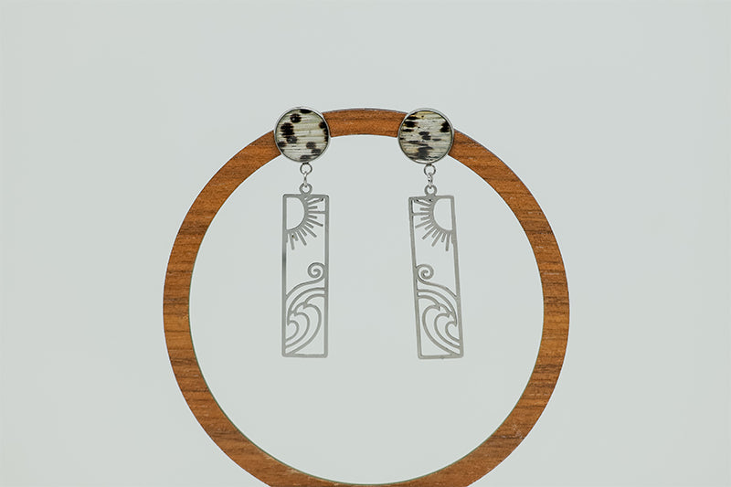 Surf + Shine Earrings on a circular wooden stand on a white background.  