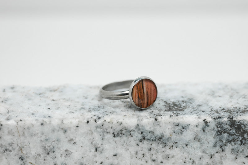 A Silver Adjustable Ring on black and white marble on a white background.