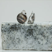 Clip-On Earrings on black and white marble on a white background.