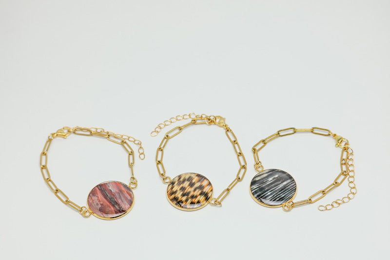 Three Gold Paperclip Bracelets on a white background. 