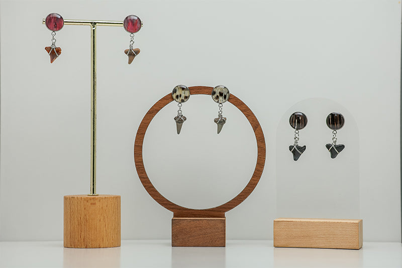 Three Shark Tooth Silver Posts on a stands on a white background. 