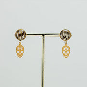 A pair of Sugar Skull Earrings on a gold stand on a white background.