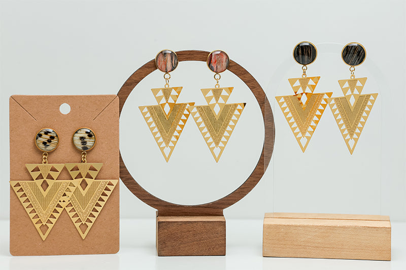 Three pairs of Aztec Inspired Earrings on stands on a white background.  