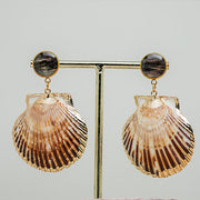 Scallop Shell Statement Earrings on a gold stand on a white background.