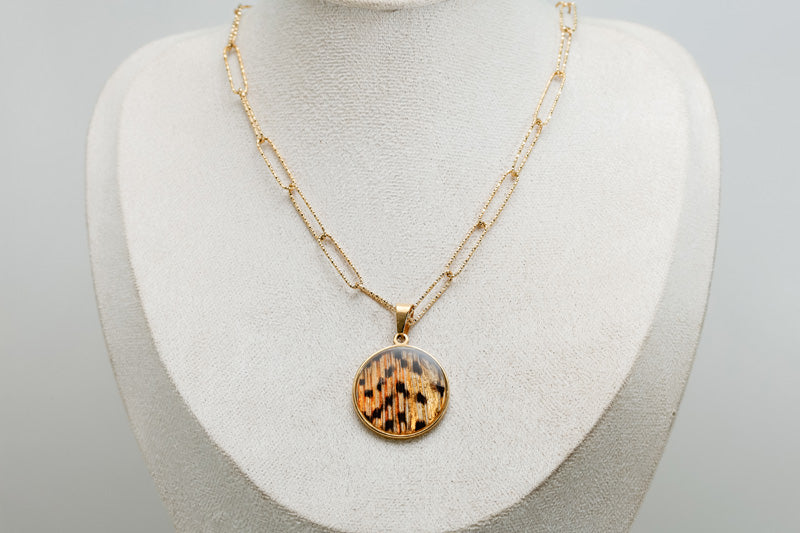 An X-Large Gold Necklace on a cream necklace display bust. 