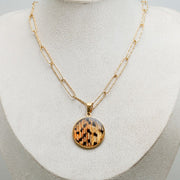An X-Large Gold Necklace on a cream necklace display bust. 
