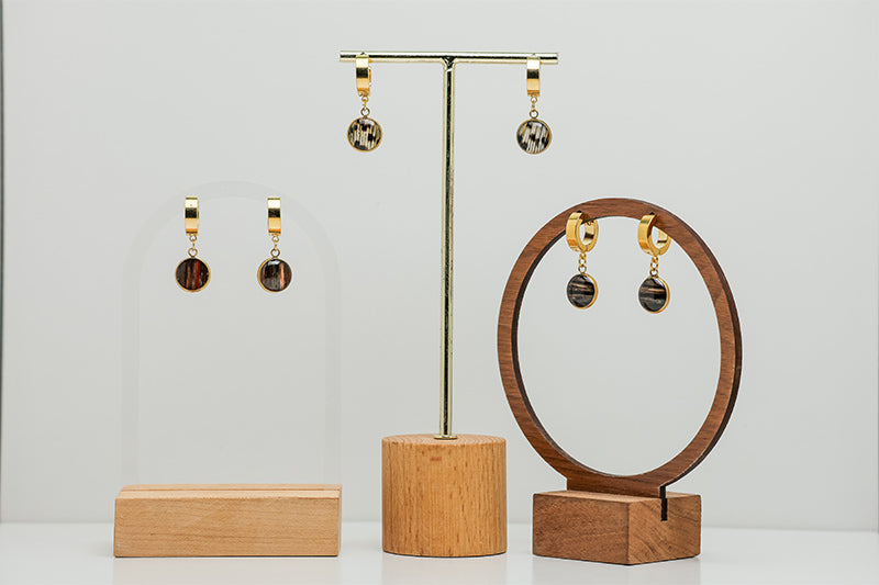 Three pairs of  Golden Huggies on stands on a white background.  