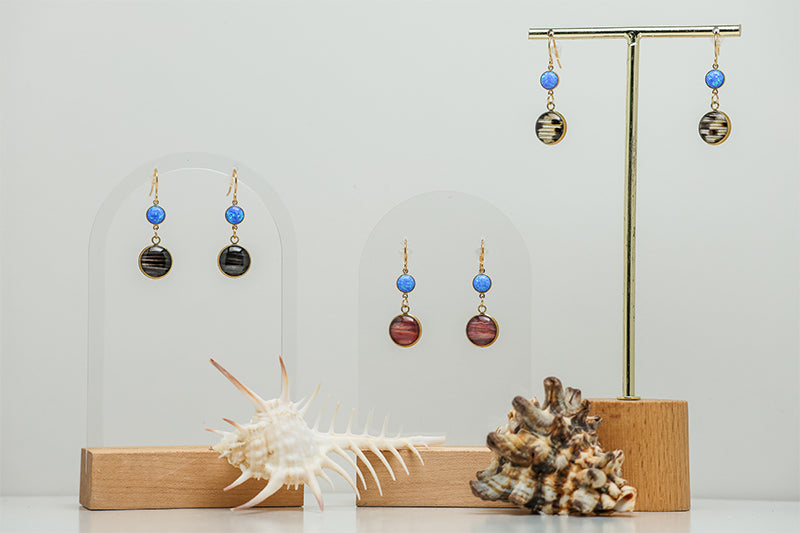 Three pairs Caribbean Blue Opal Earrings  on a white background with two shells at the bottom of the image. 