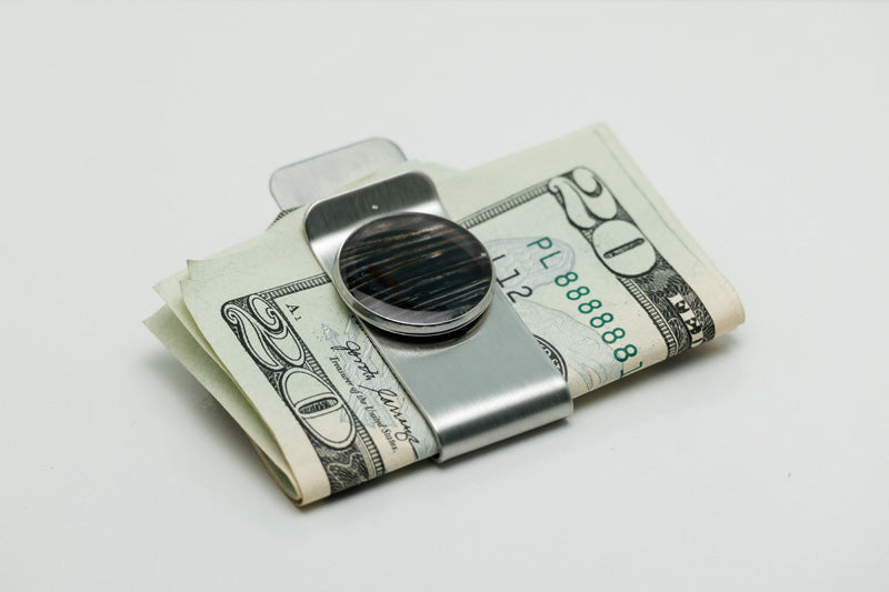 Silver Money Clip on a $20 bill on a white background. 