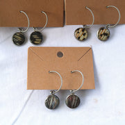 Three pairs of Silver Open Hoop Posts on cardboard stands on a white background with shells at the top of the image.  