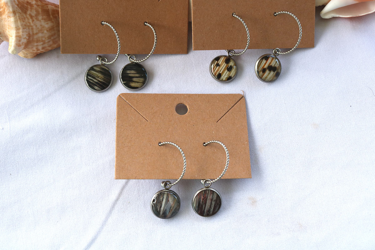 Three pairs of Silver Open Hoop Posts on cardboard stands on a white background with shells at the top of the image.  
