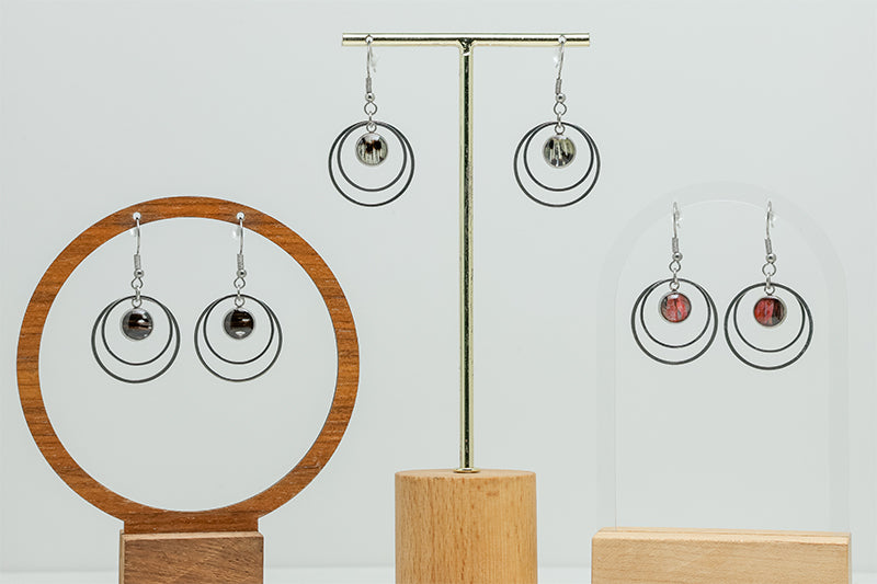 Three pairs of Small Silver Double Loops on stands on a white background. 