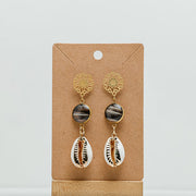 Cowrie Shell Mandala Drops on a cardboard stand on a white background.  