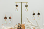 Three pairs of Opal Slice Earrings stands on a white background with two shells and white coral at the bottom of the image. 