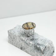A Silver Statement Ring on black and white marble on a white background.