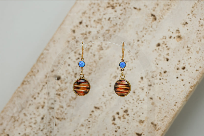 Closeup of Petite Caribbean Blue Opal Earrings with white marble in the background. 