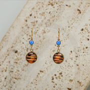 Closeup of Petite Caribbean Blue Opal Earrings with white marble in the background. 
