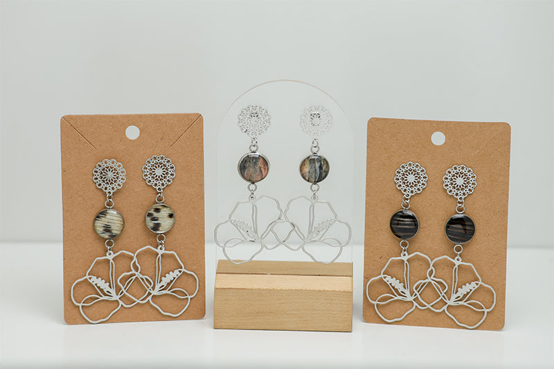 Three pairs of Hibiscus Mandala Drops on stands on a white background. 