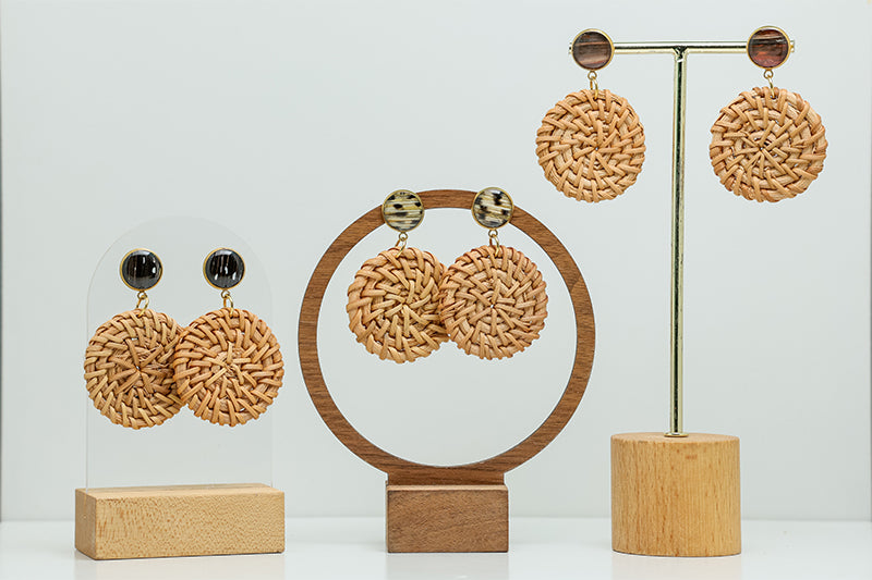 Three pairs of Boho Rattan Circular Earrings on stands on a white background.  