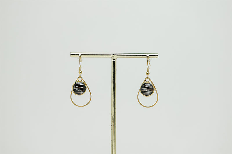 Small Golden Teardrop Earrings on a gold stand on a white background.