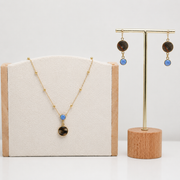 Lionfish Necklace and earrings with blue opals on display with a neutral background