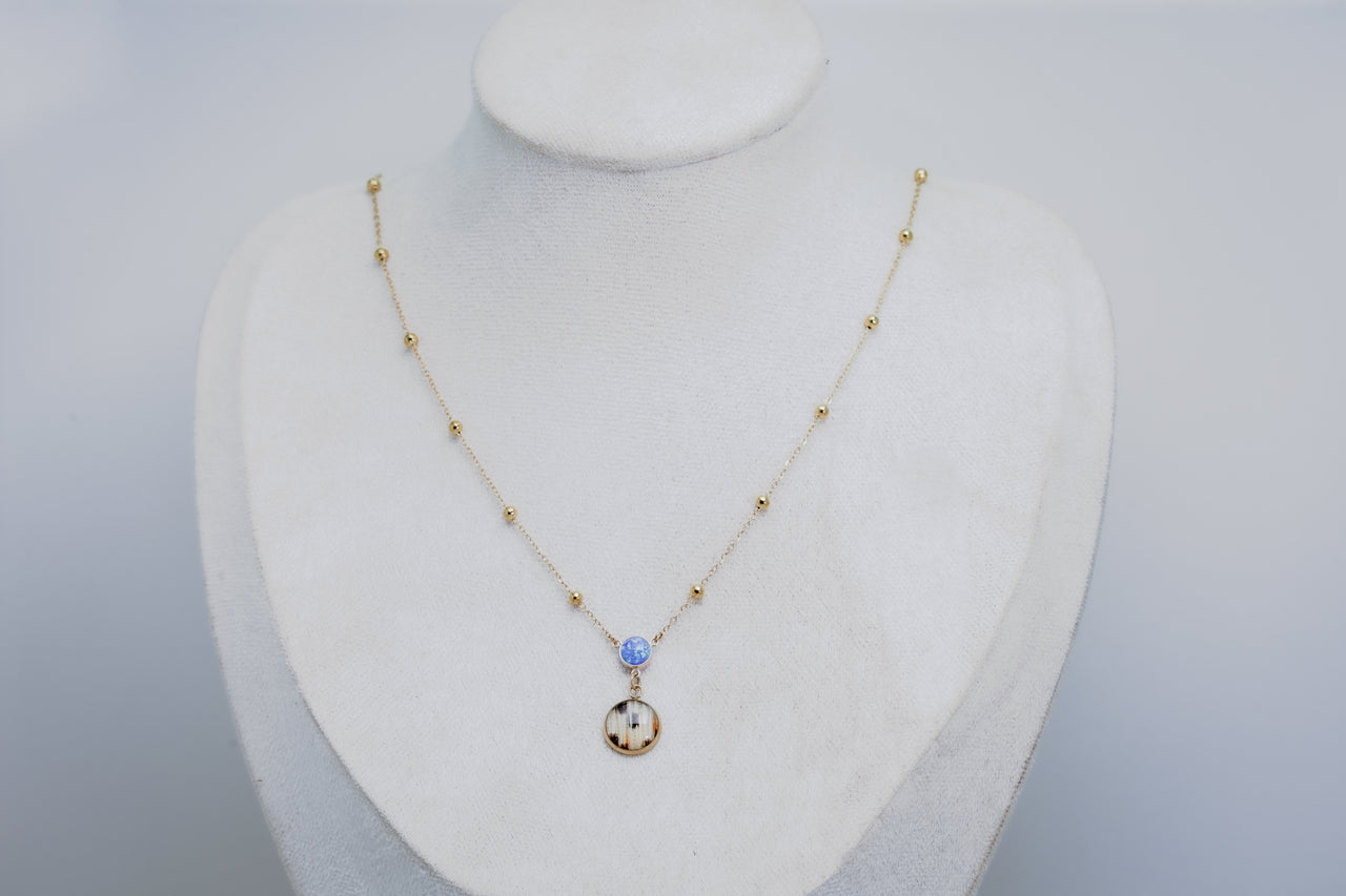 Necklace with a pendant on a mannequin bust against a gray background
