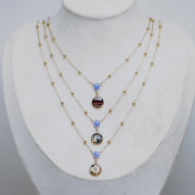 Three Necklaces with blue opal beads on a mannequin bust against a gray background