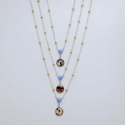 Three layered necklaces with blue opals on a light gray background