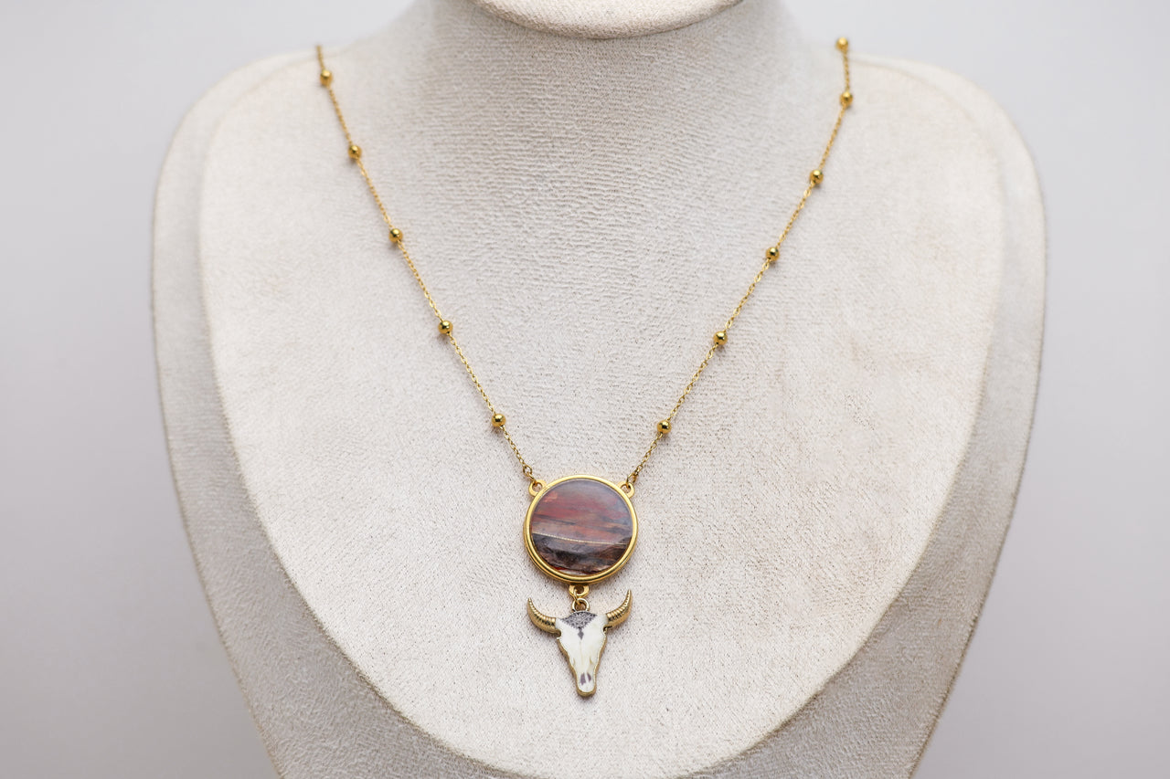 Necklace with a lionfish pendant featuring a cow head design on a mannequin bust.