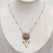 Necklace with a lionfish pendant featuring a cow head design on a mannequin bust.