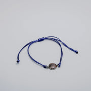Navy bracelet with a lionfish charm on a light gray background